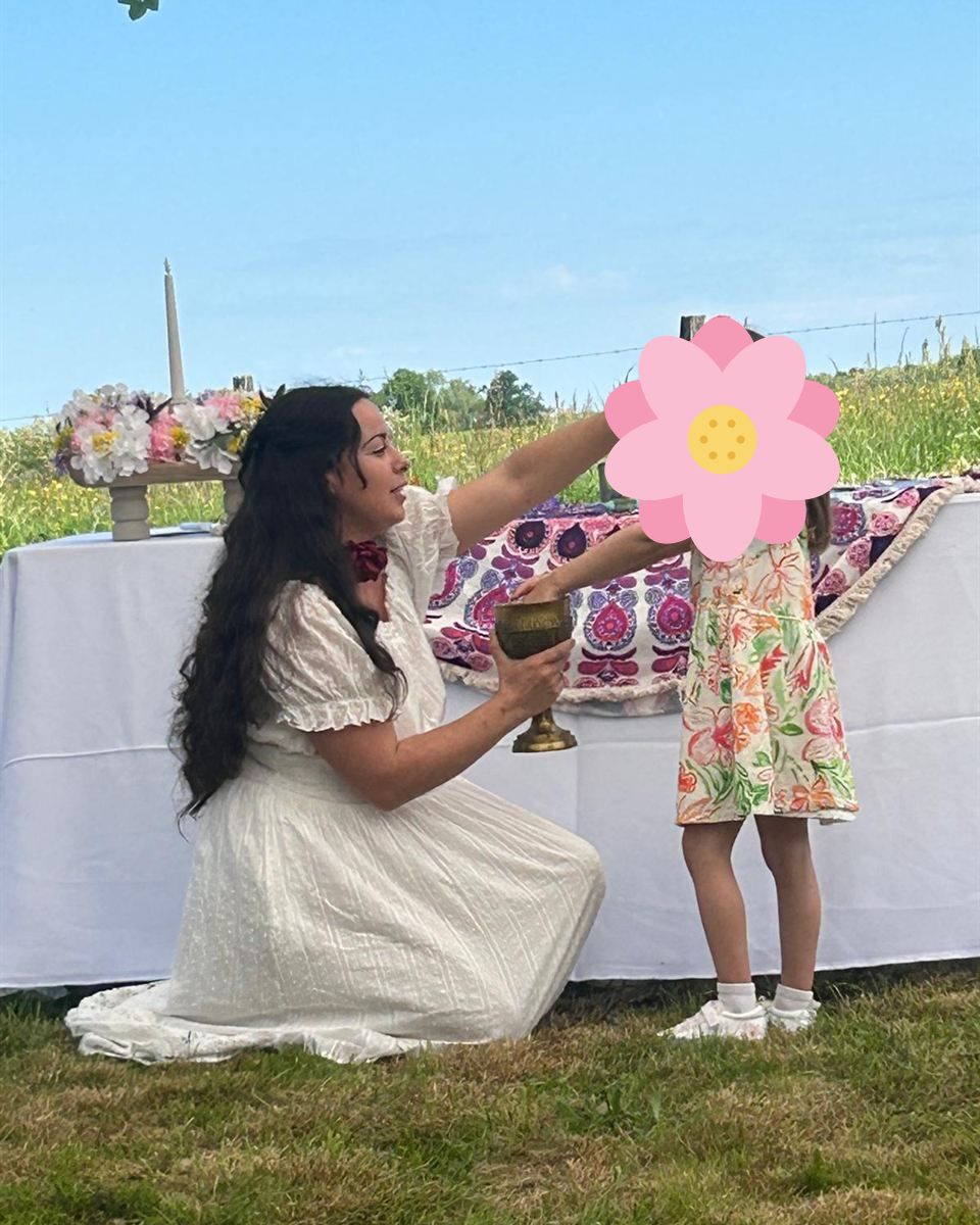 Bénédiction au calice lors d'un baptême païen sur le thème des fleurs, en plein air