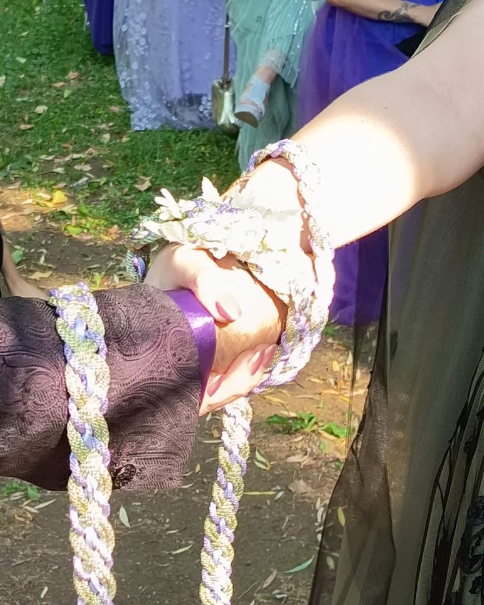 Handfasting : les mains des mariés liées par une corde tressée lors d'une cérémonie de mariage païen